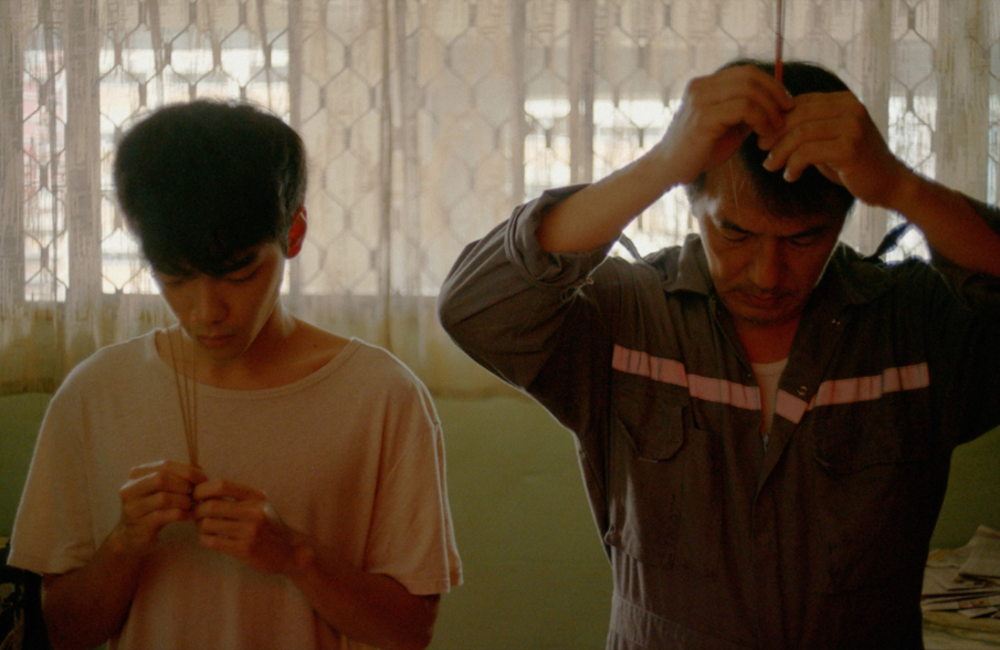 Scene from the movie Tomorrow is a long time: a father and a son together not watching ech other