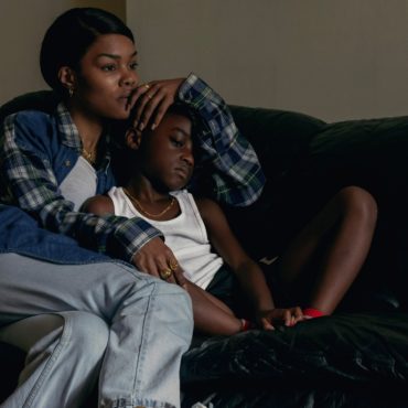 A woman and a little girl are seated on the couch